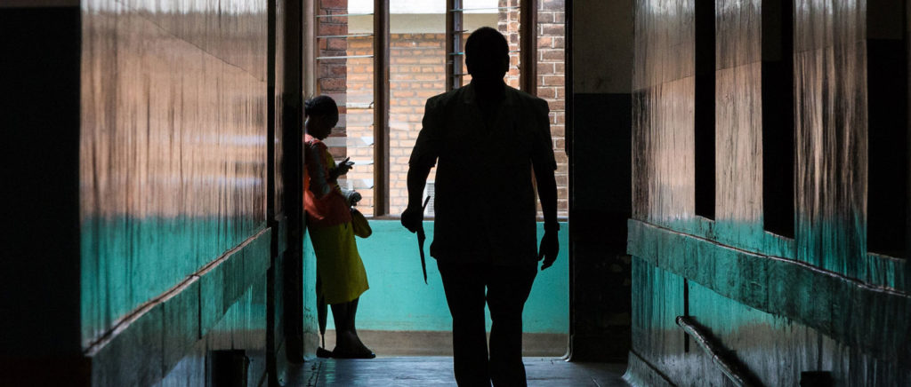 Two people pictured in a hallway at Queen Elizabeth Hospital in Malawi